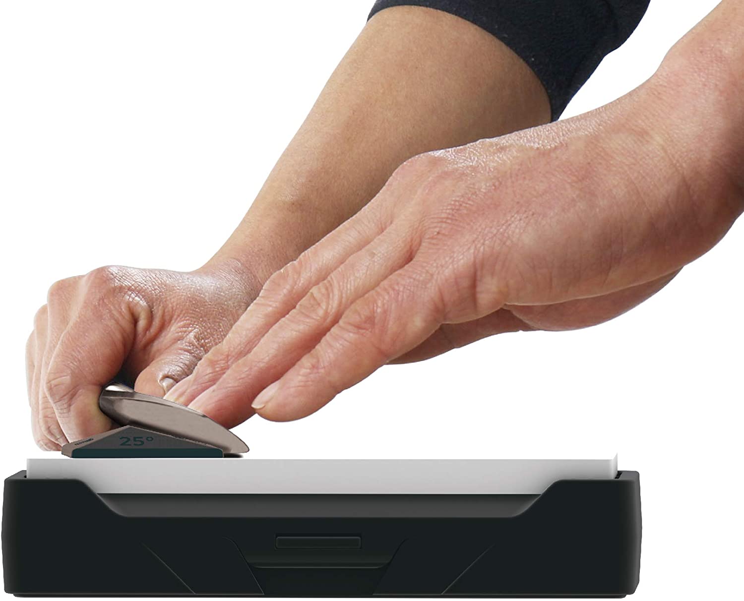Person sharpening a knife on a black and white whetstone with a white background