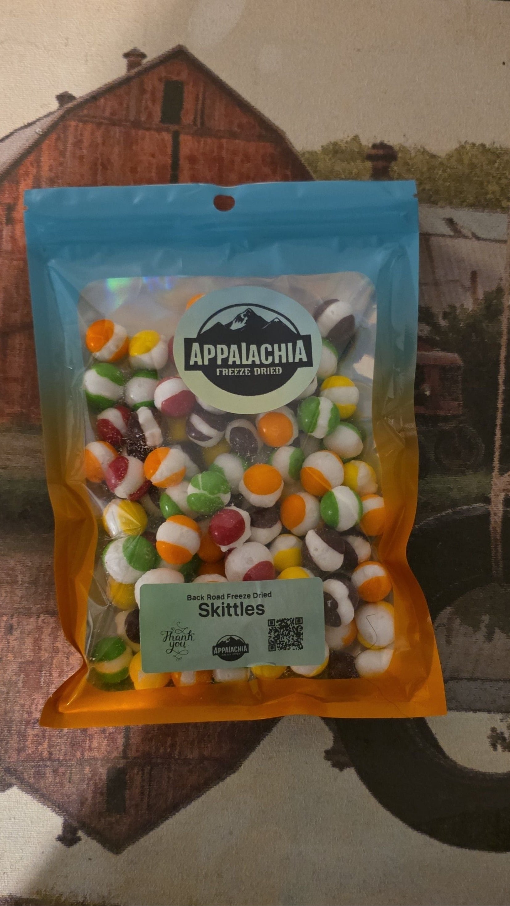 Bag of Skittles candy with a scenic background