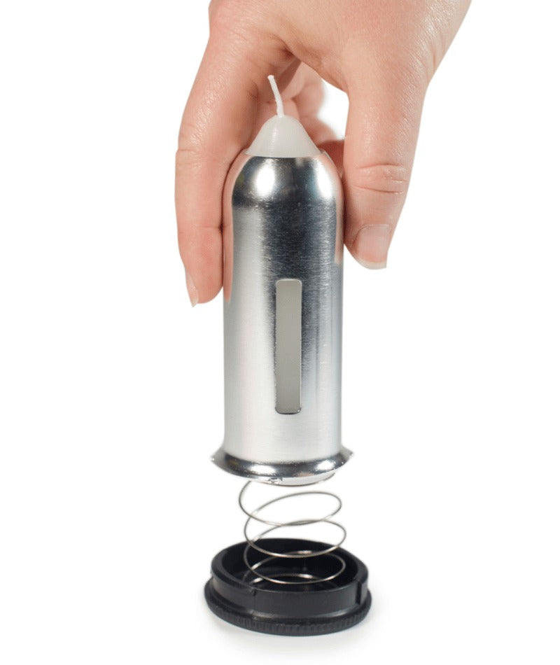 A hand holding a metallic cylindrical product with a spring and black base against a plain white background.