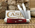 Two pocket knives with red handles on a wooden surface, with 'Case' branding visible.