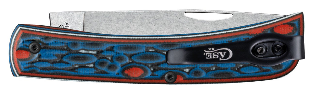 A folding pocket knife with a textured silver steel blade and a handle featuring a blue and red bubbly pattern with a black clip, shown against a plain white background.